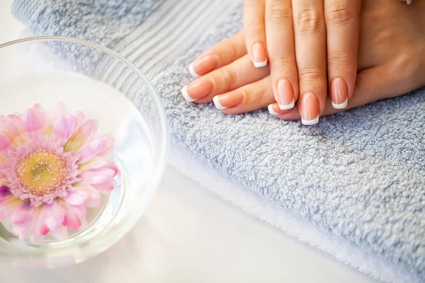 Beaux ongles de femme avec manucure française, dans un studio de beauté — Photo