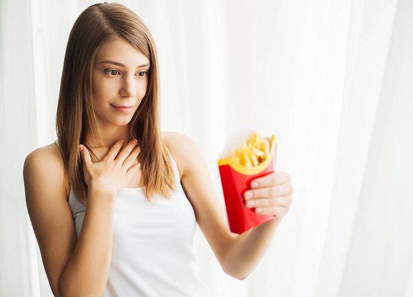Woman Measuring Body Weight On Weighing Scale Holding Unhealthy Junk Food