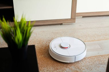 Akıllı ev. Robot elektrikli süpürge daireyi belli bir zamanda otomatik olarak temizliyor.