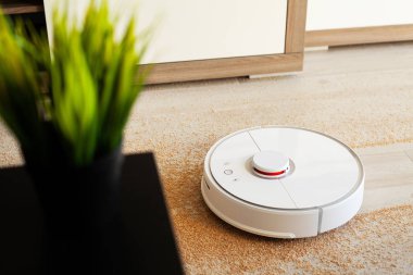 Akıllı ev. Robot elektrikli süpürge daireyi belli bir zamanda otomatik olarak temizliyor.