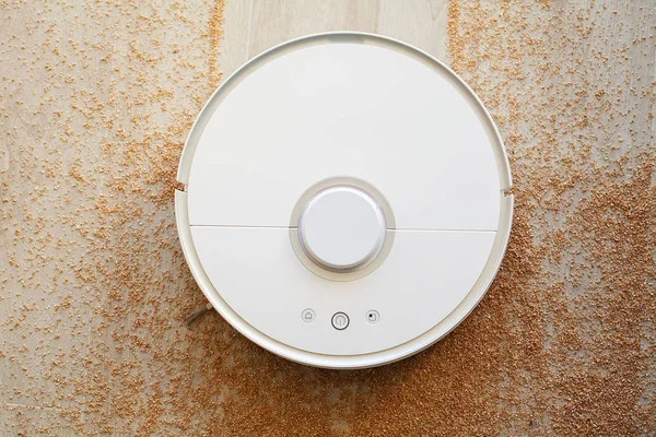Smart home. Robot vacuum cleaner performs automatic cleaning of the apartment at a certain time