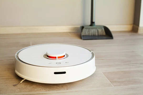 Умный дом. Робот-пылесос выполняет автоматическую очистку квартиры в определенное время — стоковое фото