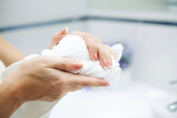 Hygiène et soin des mains. Femme utilisant une serviette pour essuyer les mains sécher après le lavage dans la salle de bain légère à la maison — Photo