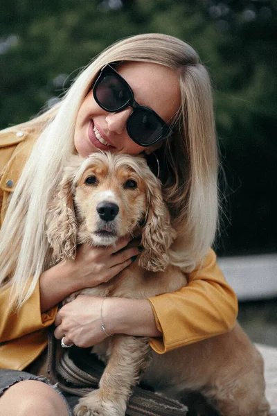 Gürültü ve klasik tarz. Köpekli genç kız parkta yürüyor ve güzel yaz gününün tadını çıkarıyor. — Stok fotoğraf