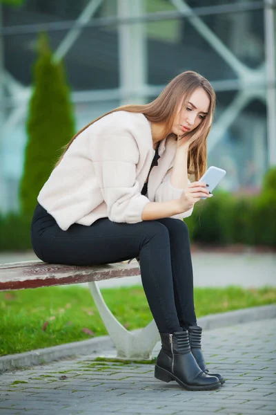 Upprörd kvinna med problem att sitta på en bänk. — Stockfoto