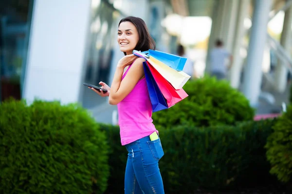Černý pátek. Šťastná žena v blízkosti nákupního centra drží dárkové tašky — Stock fotografie