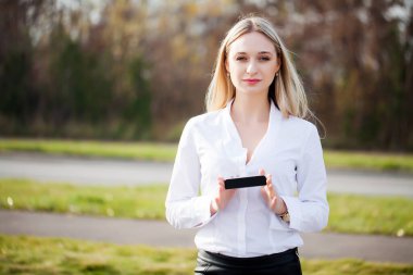 Kadın, açık havada yeni teknoloji ürünü sunuyor