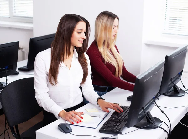 Dos hermosas chicas trabajan en la oficina de una empresa de consultoría — Foto de Stock