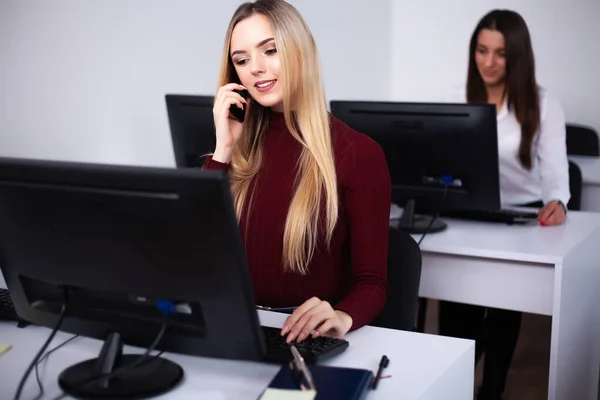 Two beautiful girls work in the office of a consulting company — Stock Photo, Image