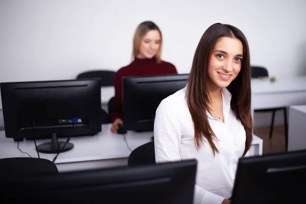 Two beautiful girls work in the office of a consulting company — Stock Photo, Image