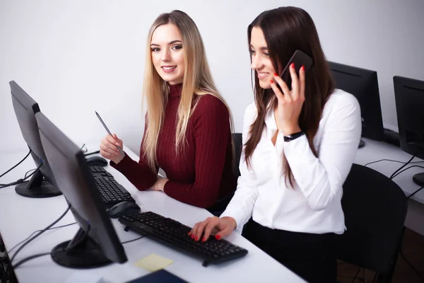 Two beautiful girls work in the office of a consulting company — Stock Photo, Image