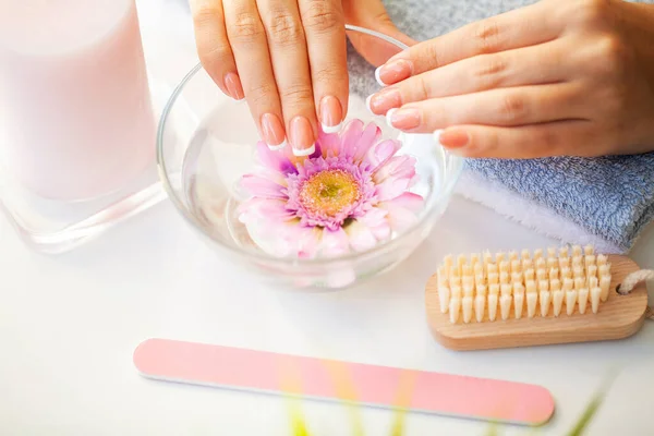 Nails care. Beautiful womans nails with french manicure, in beauty studio