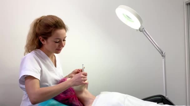 Wellnesstherapie für junge Frau mit Gesichtsmaske im Schönheitssalon. — Stockvideo