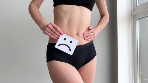Zdraví ženy. Ženské tělo drží smutný úsměv kartu v blízkosti žaludku — Stock video