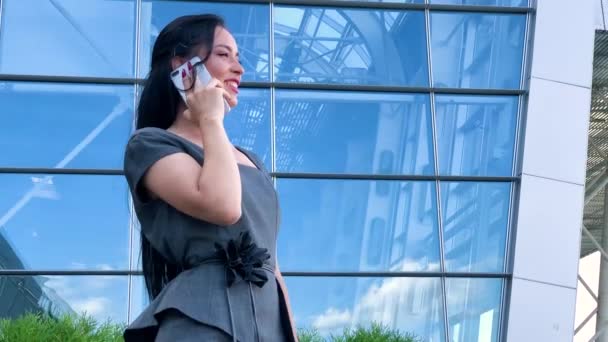 Reisen. Geschäftsfrau am Flughafen spricht auf dem Smartphone, während sie mit Handgepäck am Flughafen zum Gate geht. — Stockvideo