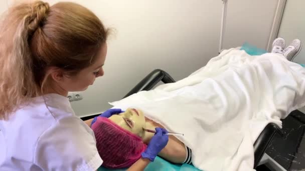 Terapia de spa para mulher jovem com máscara facial no salão de beleza . — Vídeo de Stock