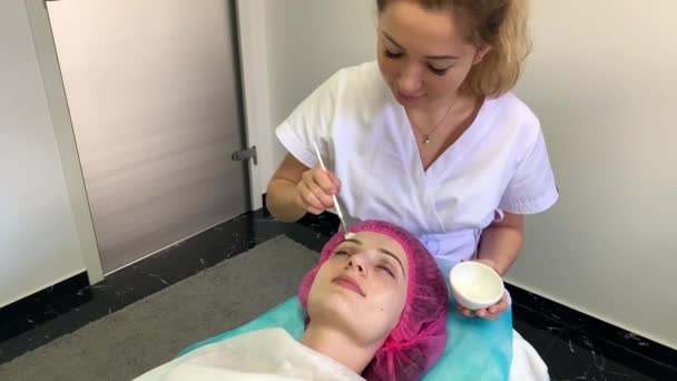 Terapia de spa para mulher jovem com máscara facial no salão de beleza . — Vídeo de Stock