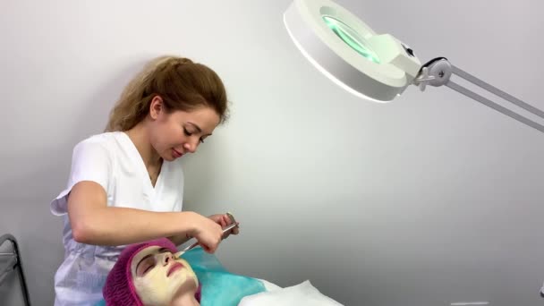 Terapia de spa para mulher jovem com máscara facial no salão de beleza . — Vídeo de Stock