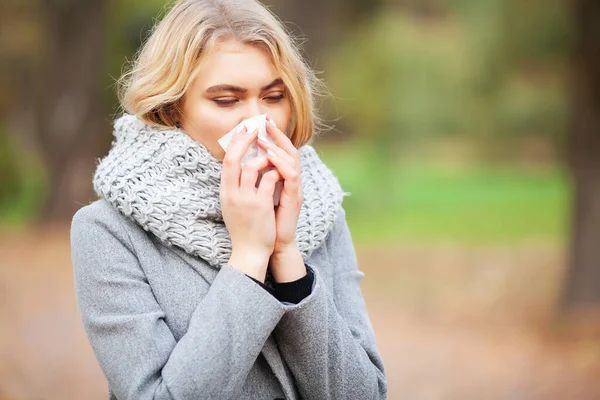 Mujer retrato al aire libre estornudos porque el frío y la gripe — Foto de Stock