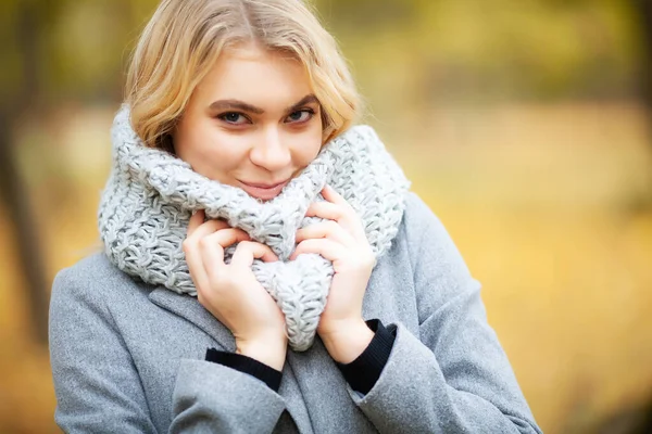 Resfriado y gripe. Mujer joven con un abrigo gris caminando en el parque de otoño —  Fotos de Stock