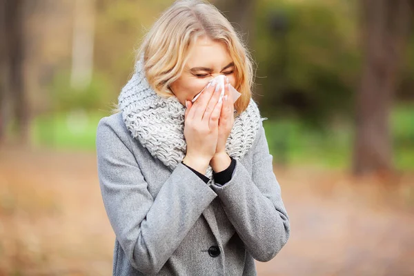 Mujer retrato al aire libre estornudos porque el frío y la gripe — Foto de Stock