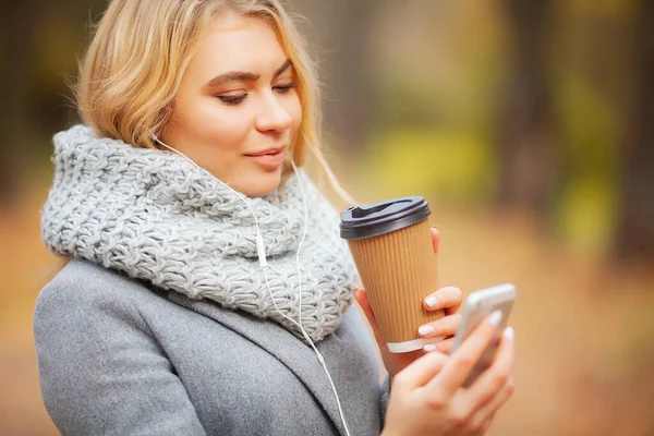 Kaffe att gå. Ung kvinna med kaffe i parken hösten — Stockfoto