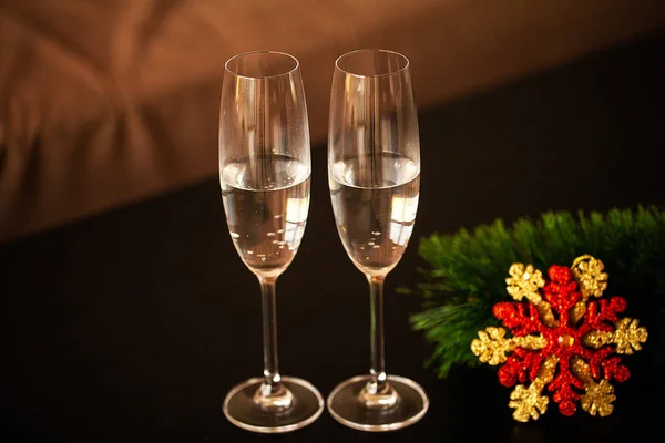 Glasses filled with champagne on Christmas background