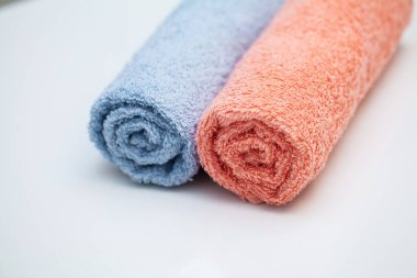 Banyo arka planında beyaz masanın üzerine havlular..