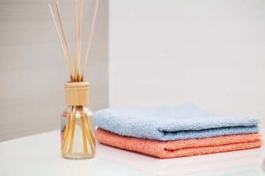 Banyo arka planında beyaz masanın üzerine havlular..