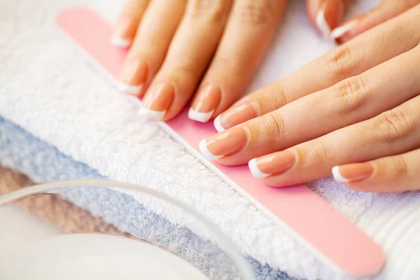 Les ongles comptent. Beaux ongles de femme avec manucure française, dans un studio de beauté — Photo