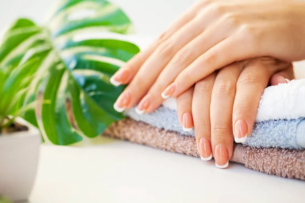 Naglar bryr sig. Vackra kvinnors naglar med fransk manikyr, i skönhetsstudio — Stockfoto