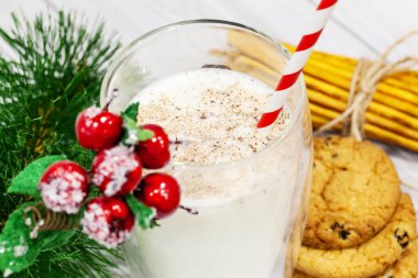 Beyaz arka planda Noel kurabiyeleri ve sütle kompozisyon