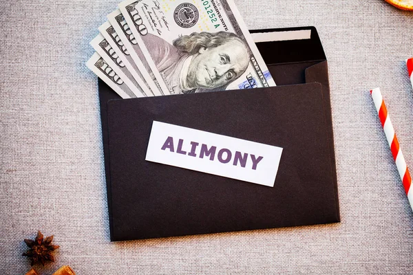 Alimony in a black envelope on a Christmas background