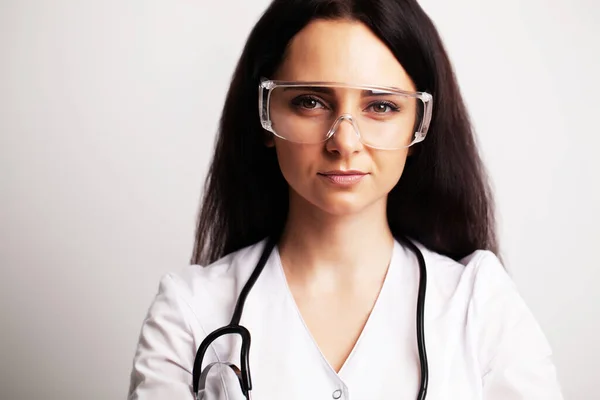 Portrait of a doctor with glasses and a white medical gown looking at the camera — Stock Photo, Image