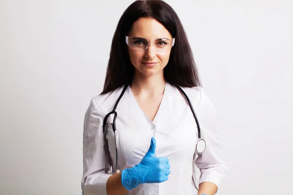 Retrato de un médico con gafas y un vestido médico blanco mirando a la cámara —  Fotos de Stock