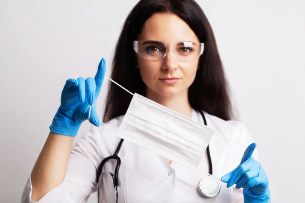 Retrato de um médico de óculos e um vestido médico branco que usa equipamento de proteção individual — Fotografia de Stock