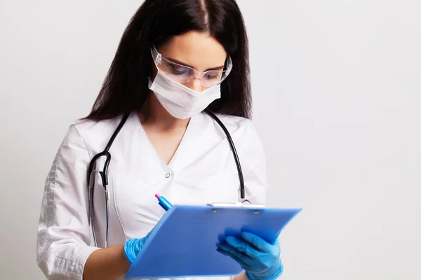 Mulher médico na clínica preenche cartão médico ambulatorial — Fotografia de Stock