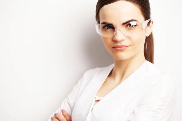 Portrait of a doctor with glasses and a white medical gown looking at the camera — Stock Photo, Image