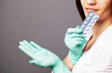 Cinsel sağlık, beyaz önlüklü bir doktor sağlıklı bir seks hayatı için hap tutuyor.