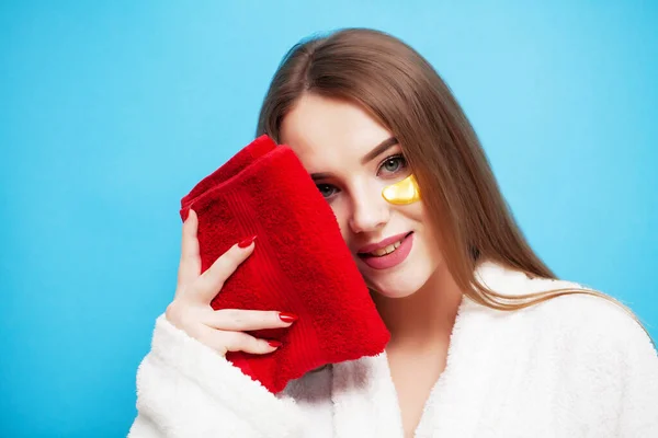 Young woman wipes face with soft towel after spa treatments