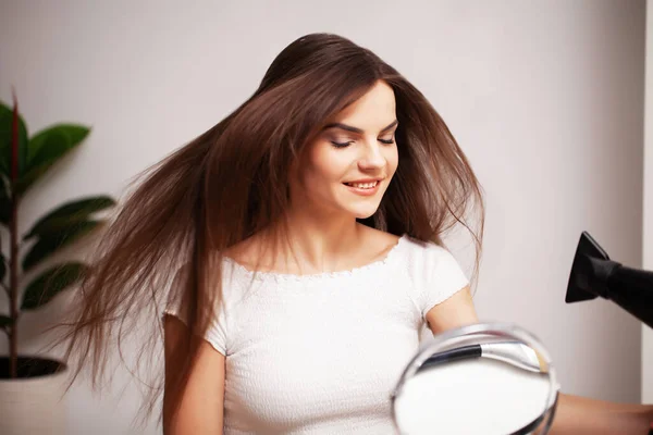 Όμορφη γυναίκα χρησιμοποιεί στεγνωτήρα μαλλιών για να στεγνώσει τα μαλλιά της μετά από ένα ντους — Φωτογραφία Αρχείου