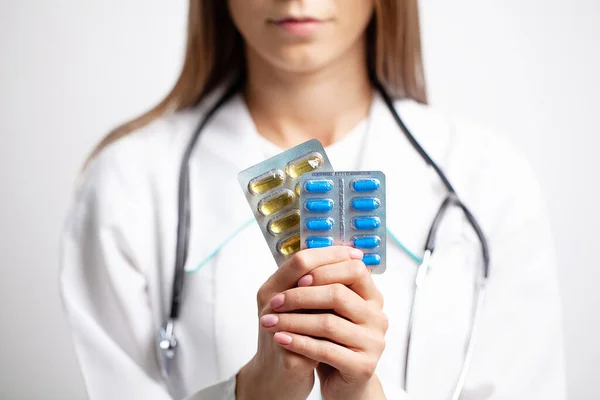 Médica feminina segurando pílulas em suas mãos — Fotografia de Stock