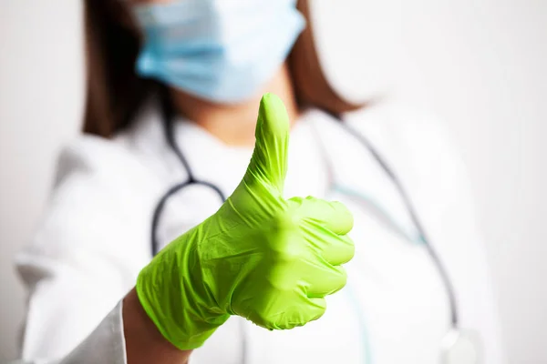 Joven médico muestra en guantes el símbolo del bien — Foto de Stock