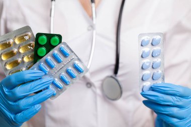 Kadın doktor elinde haplar tutuyor.