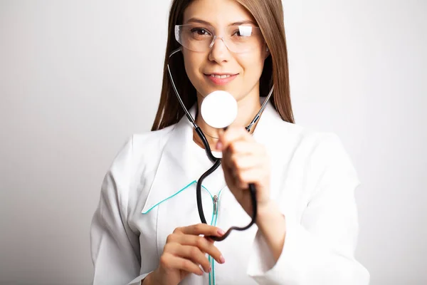 Mujer doctora sosteniendo estetoscopio en las manos de cerca —  Fotos de Stock