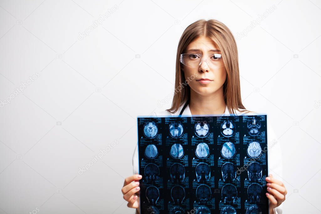 A young doctor examines an MRI image of a patient