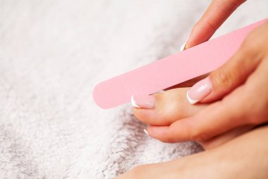 Apartmanda ayakları üzerinde pedikür yapan bir kadın.