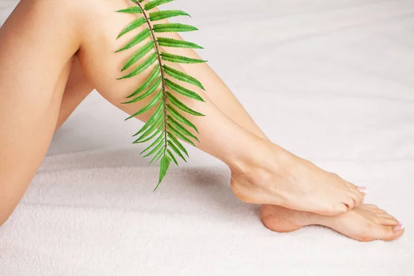 Beautiful legs of a woman with a fresh french pedicure — Stock Photo, Image