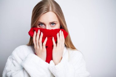 Güzel kız evde aynanın önünde yüzünü havluyla siliyor.