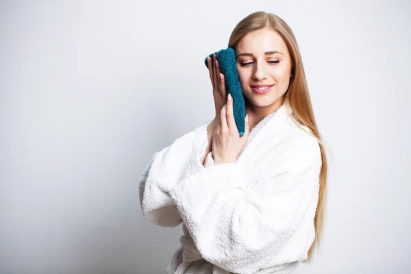 Menina bonita limpa o rosto com uma toalha em casa na frente de um espelho — Fotografia de Stock